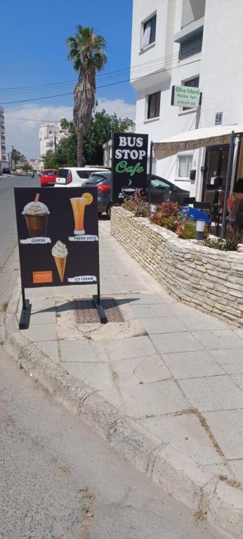 a bus stop sign on the side of a street at Olive Island in Larnaka