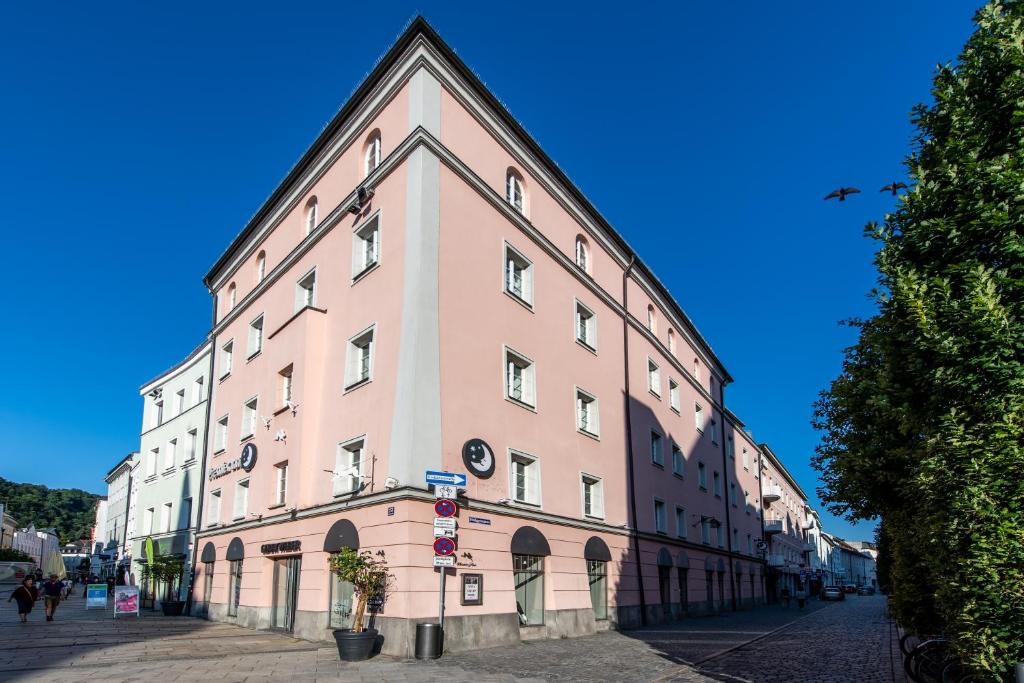 um grande edifício cor-de-rosa ao lado de uma rua em Premier Inn Passau Weisser Hase em Passau
