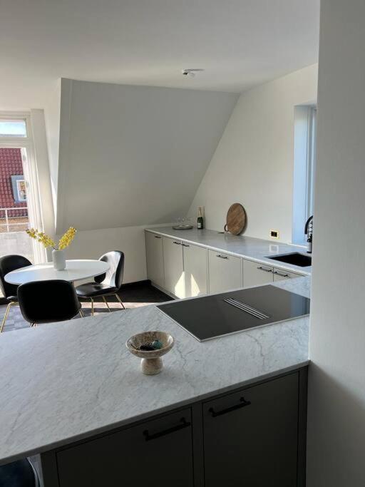 a kitchen with a counter and a table and chairs at Designer apartment in Charlottenlund