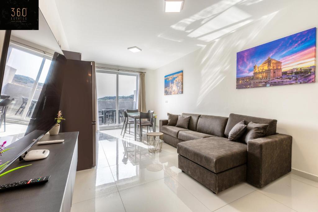 un soggiorno con divano e tavolo di A sunny 2BR Pent with comfy, fully equipped living by 360 Estates a San Pawl il-Baħar