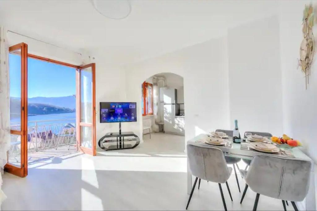 a dining room with a table and a view of the ocean at Apartment With View Lake Maggiore/Laveno Mombello in Laveno
