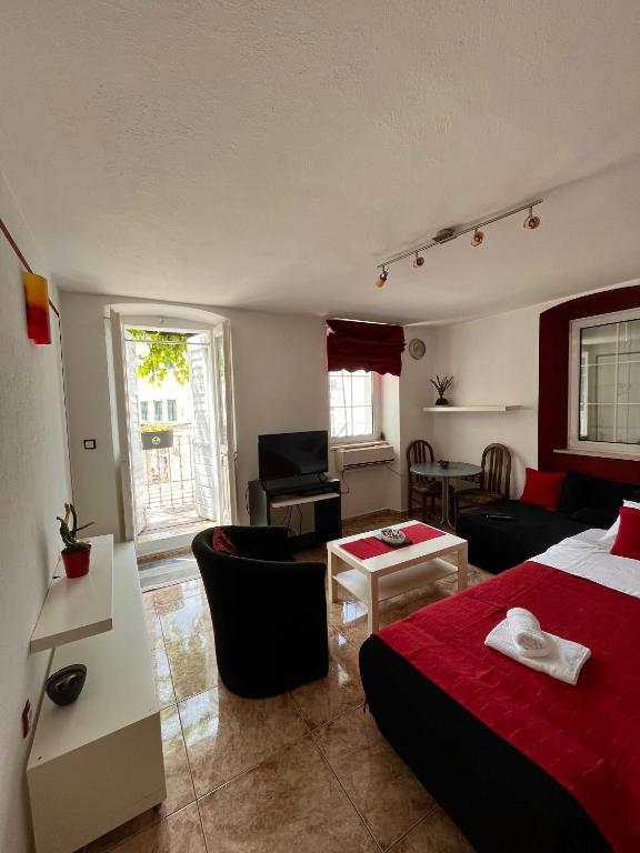 a bedroom with a bed and a living room at Hidden Gem Studio Apartment in Herceg-Novi
