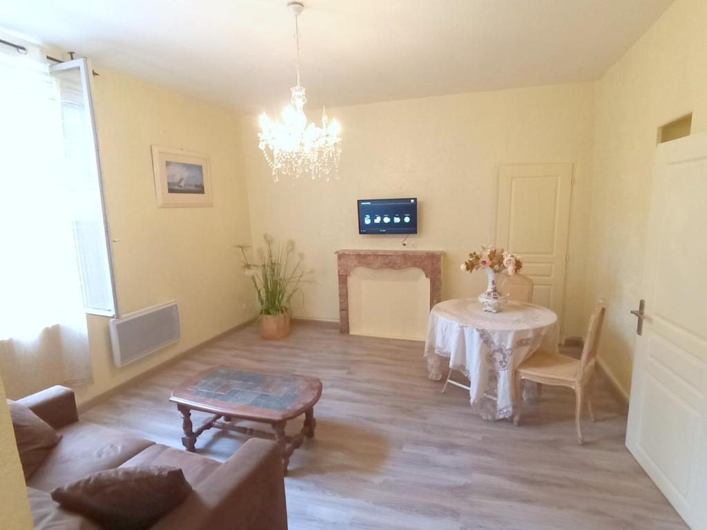 - un salon avec une table et une cheminée dans l'établissement Séjour à Béziers, à Béziers