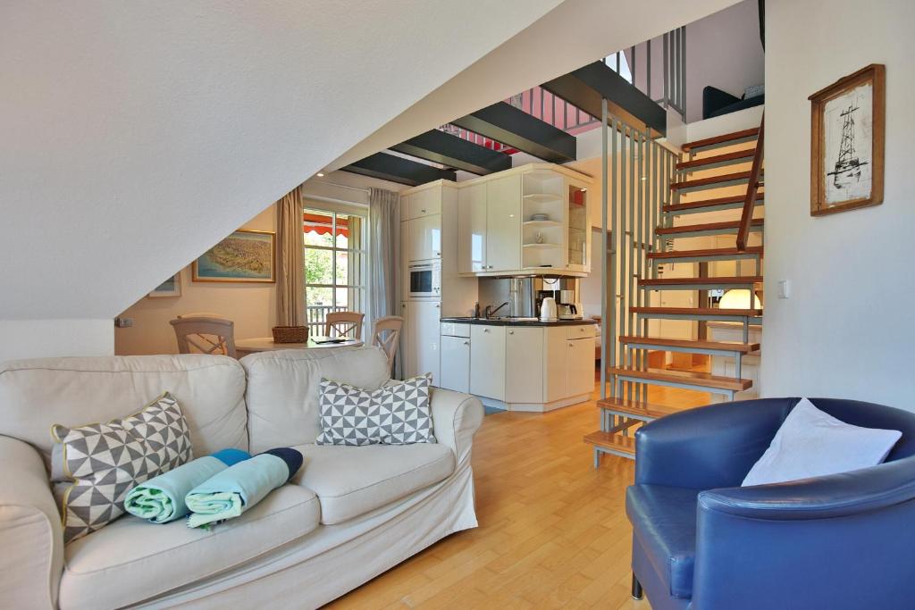 - un salon avec un canapé et un escalier dans l'établissement Am Rosenhain 19 Am Rosenhain 19 Appartement 3, à Timmendorfer Strand