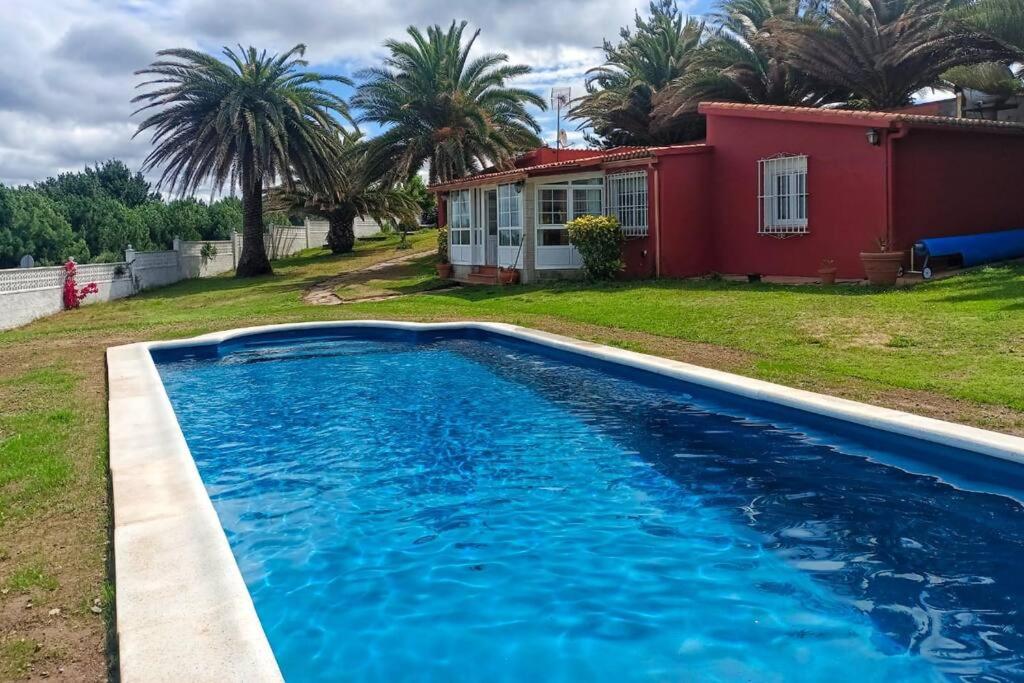 uma piscina azul em frente a uma casa em Mirador de Caión. Casa Rural completa con Piscina em Cayón