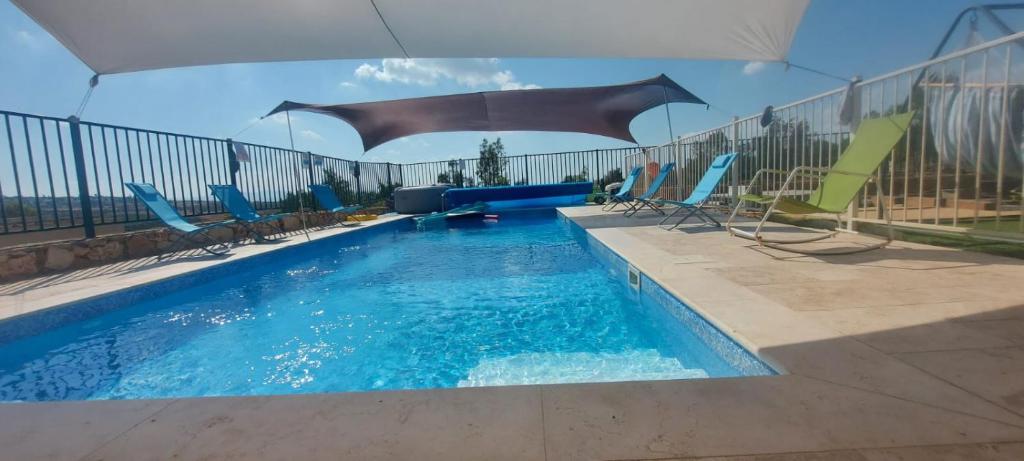 una piscina con sillas y un tobogán de agua en Gilboa Siesta / סייסטה בגלבוע en Nurit