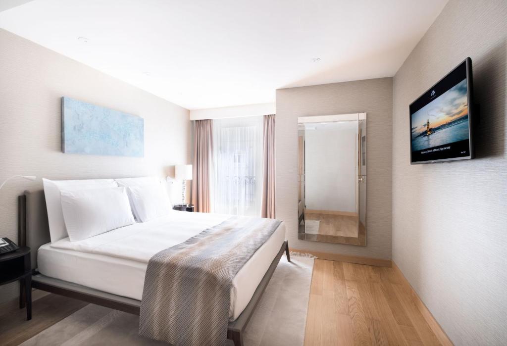 a bedroom with a bed and a tv on a wall at CVK Park Bosphorus Hotel Istanbul in Istanbul