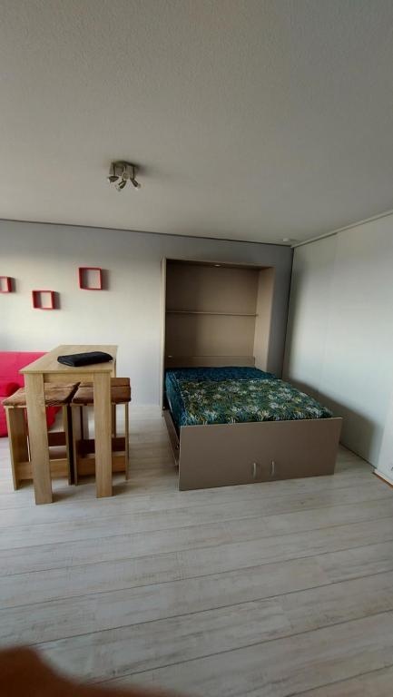a bedroom with a bed and a table in it at VACANCES OCEANES in La Rochelle