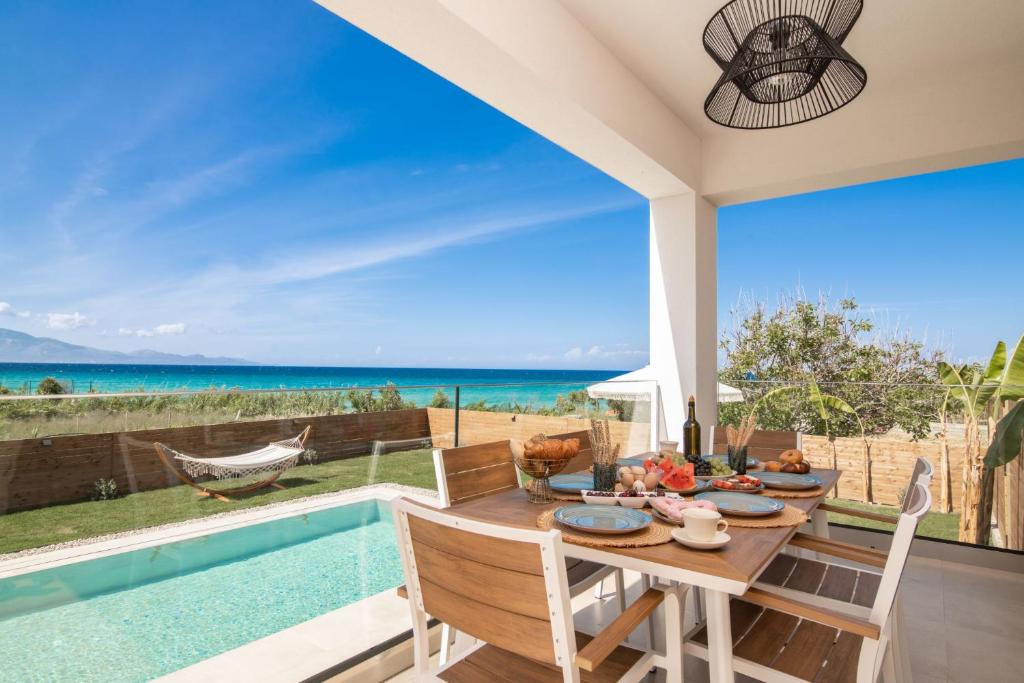 comedor con mesa y vistas al océano en Aktis Elegant Villa en Alikanas