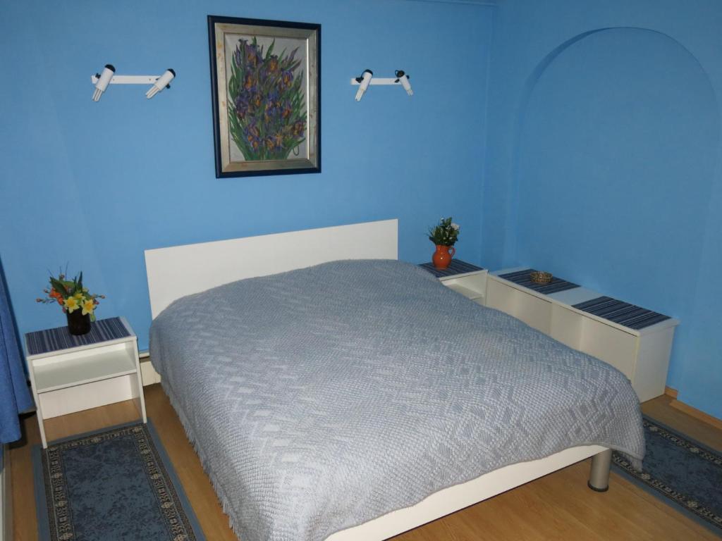 een blauwe slaapkamer met een bed en twee nachtkastjes bij Blumauer Apartments in Ljubljana