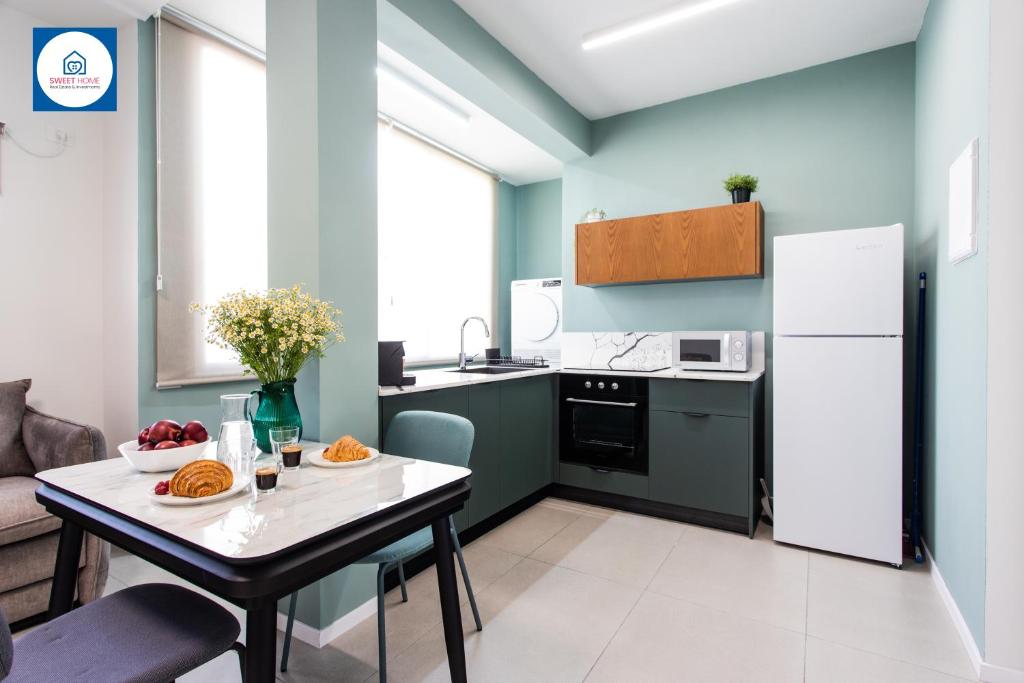 a kitchen with a table and a white refrigerator at Design apartments in Netanya in Netanya