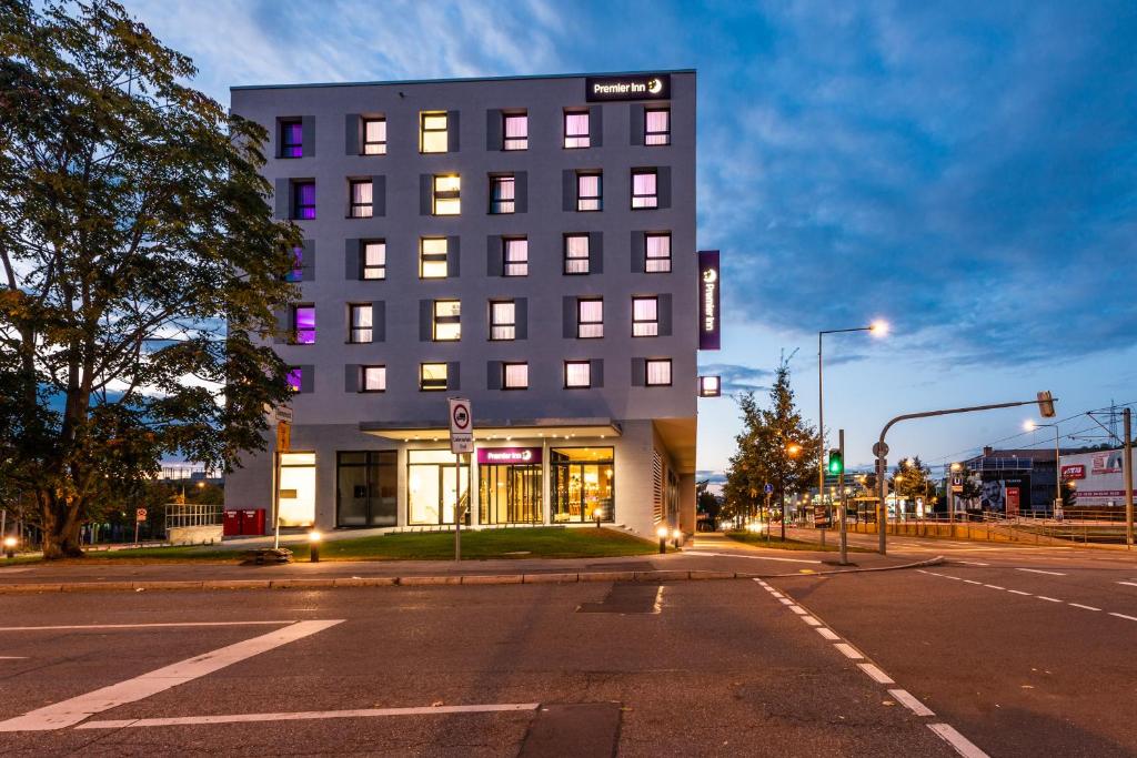 un bâtiment au coin d'une rue la nuit dans l'établissement Premier Inn Stuttgart Feuerbach, à Stuttgart