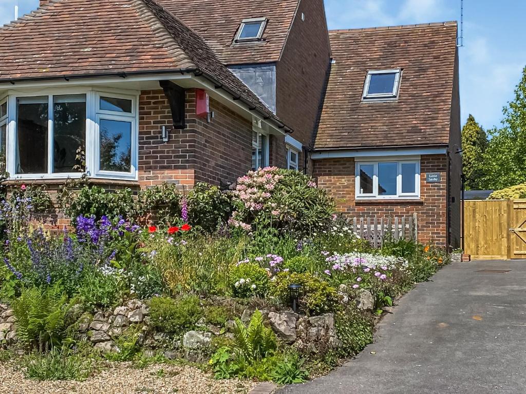 una casa de ladrillo con un jardín delante de ella en Little Saxby en Crowborough