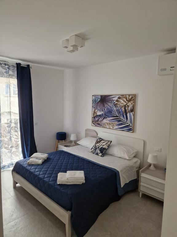 a bedroom with a large bed with a blue blanket at appartamento le onde in Terrasini