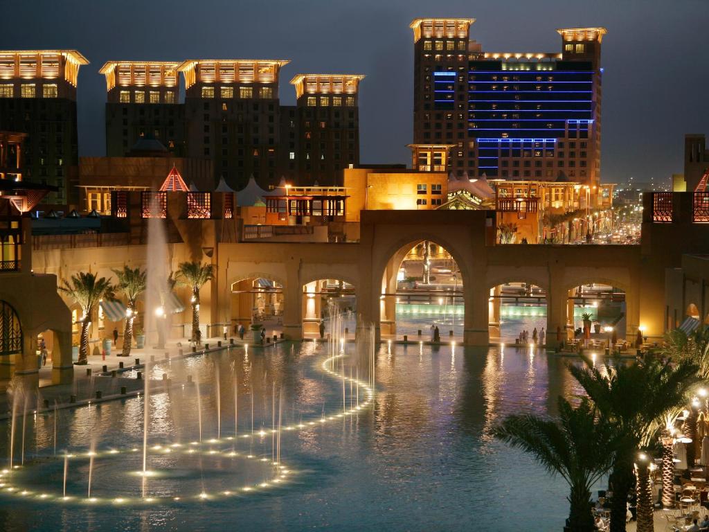 a fountain in the middle of a city at night at Hyatt Regency Al Kout Mall in Kuwait