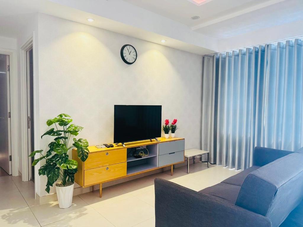 a living room with a flat screen tv on a cabinet at Sarah Homestay - Masteri Thao Dien in Ho Chi Minh City