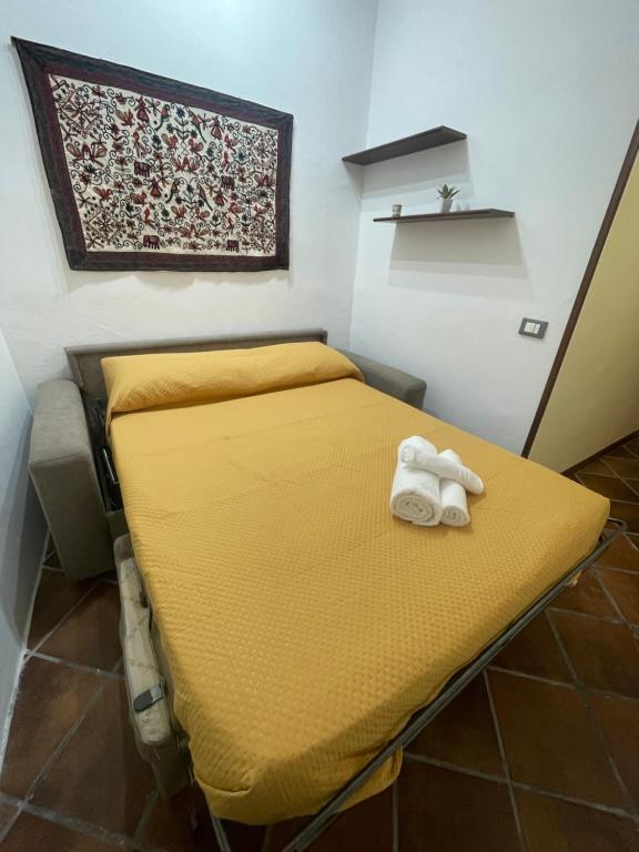 Habitación pequeña con cama con sábanas amarillas. en Cut' Home, en Monreale