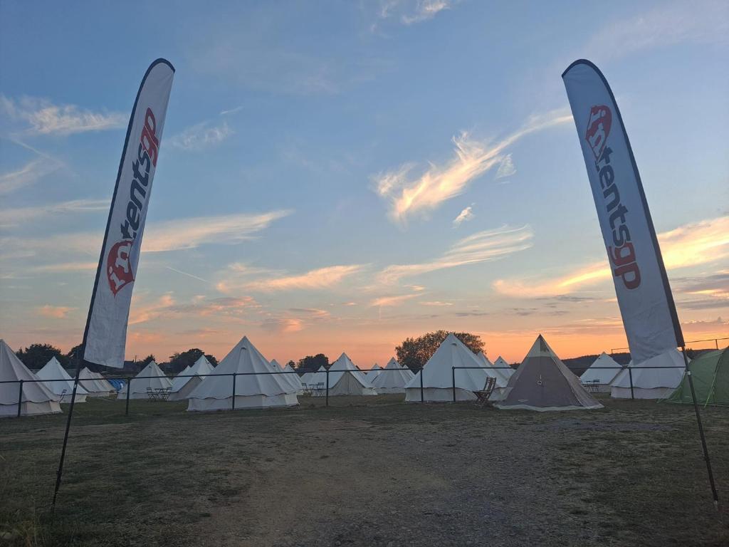 een groep tenten in een veld met zonsondergang bij IntentsGP @ Spa-Francorchamps F1 in Francorchamps