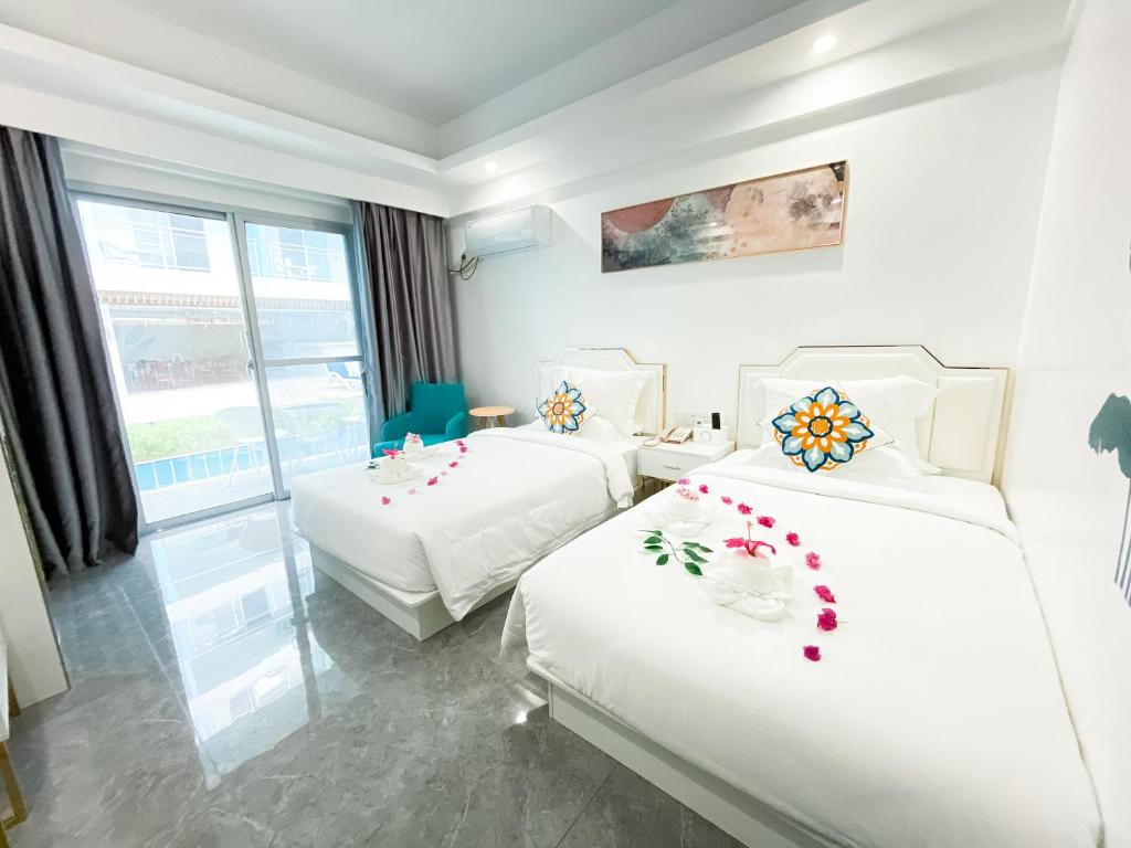 a hotel room with two beds and a window at Bohol Dolphin Bay Resort in Panglao Island