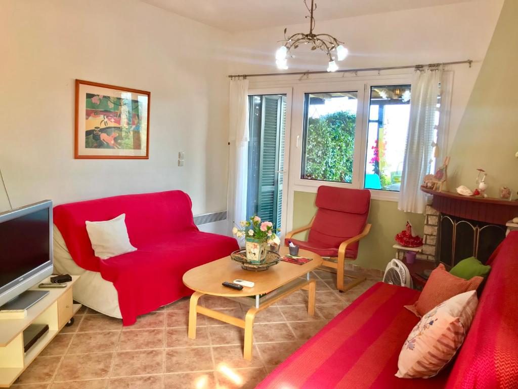 a living room with a red couch and a table at Seaside escape in Ormos Panagias