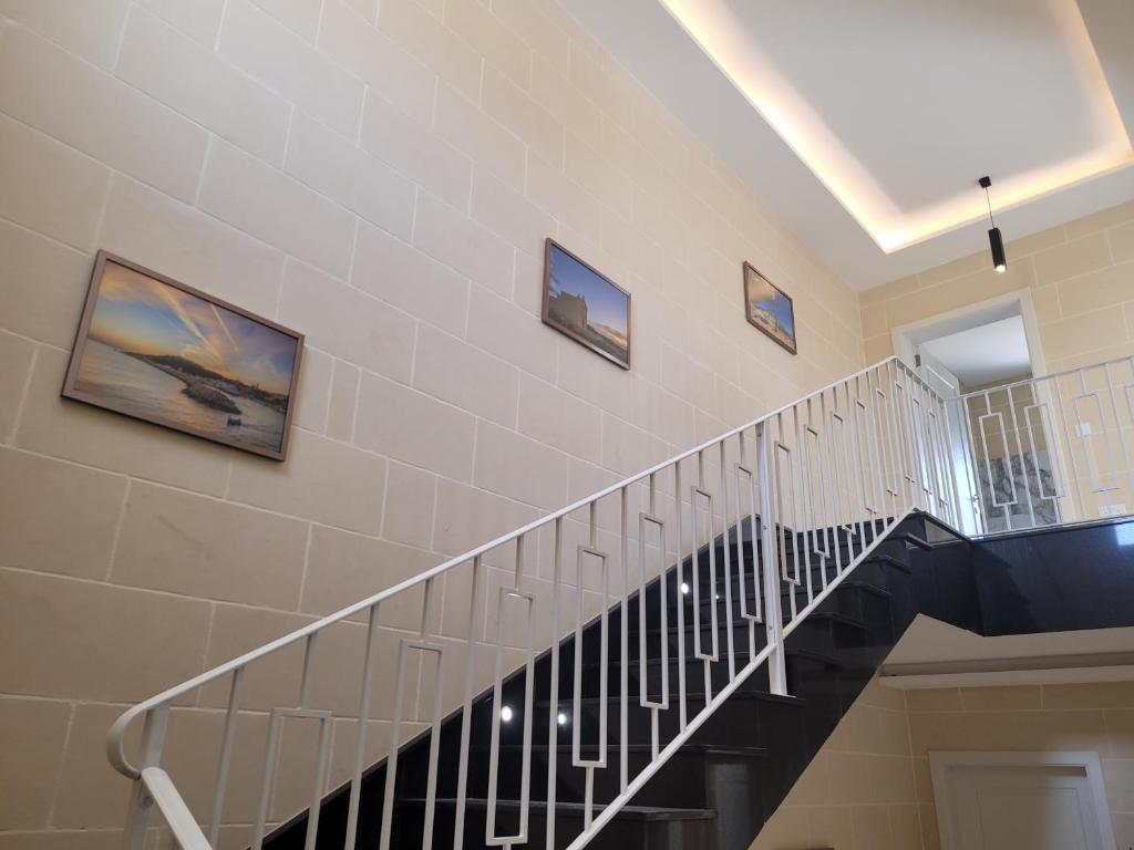 a staircase in a house with pictures on the wall at Azure W B&B in San Lawrenz