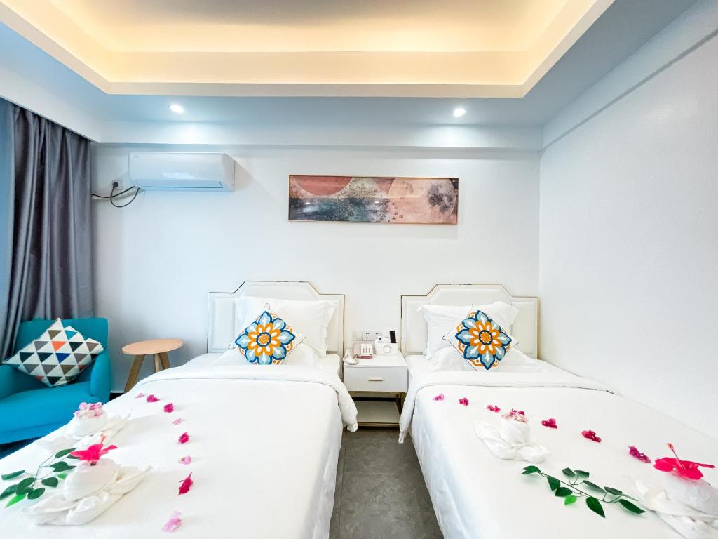 two beds in a room with white walls at Bohol Dolphin Bay Resort in Panglao