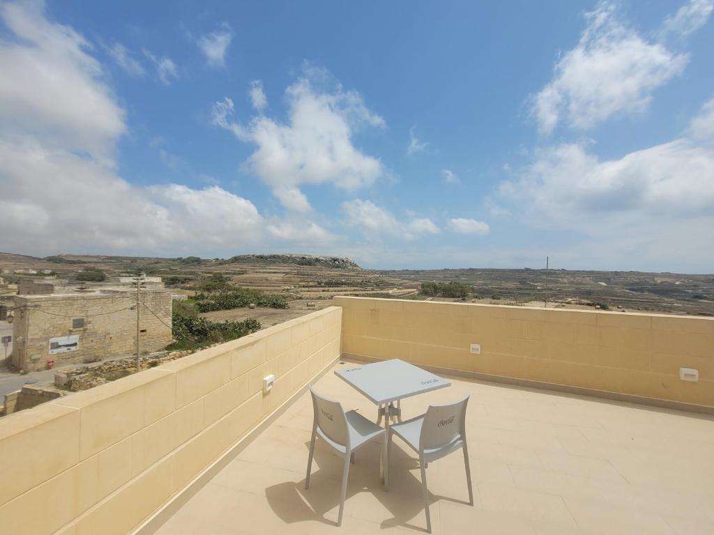 a table and two chairs on a balcony with a view at Azure W B&B in San Lawrenz