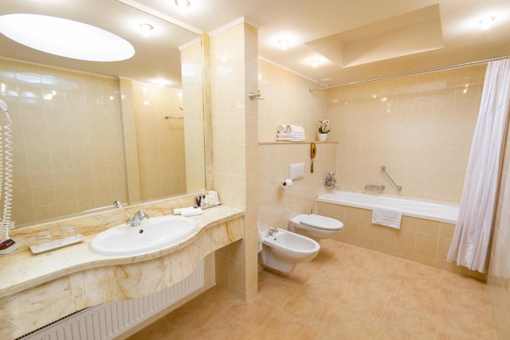 a bathroom with a sink and a toilet and a tub at Hotel Mazurkas in Ożarów Mazowiecki