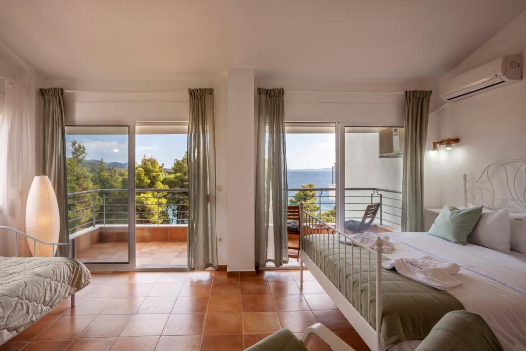 a bedroom with two beds and a balcony at Alterra Vita Homes By the Sea in Neos Marmaras