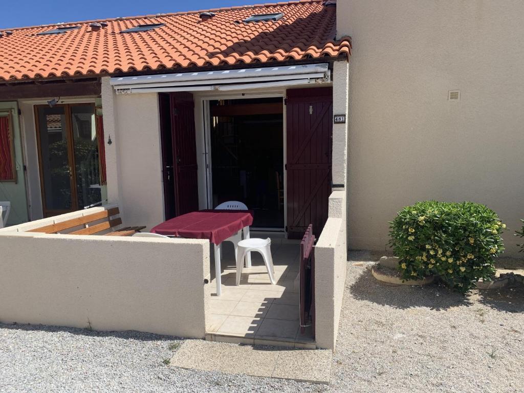 une terrasse couverte d'une maison avec une table et une chaise dans l'établissement Maison 6P - Lac Marin, à Port-Leucate