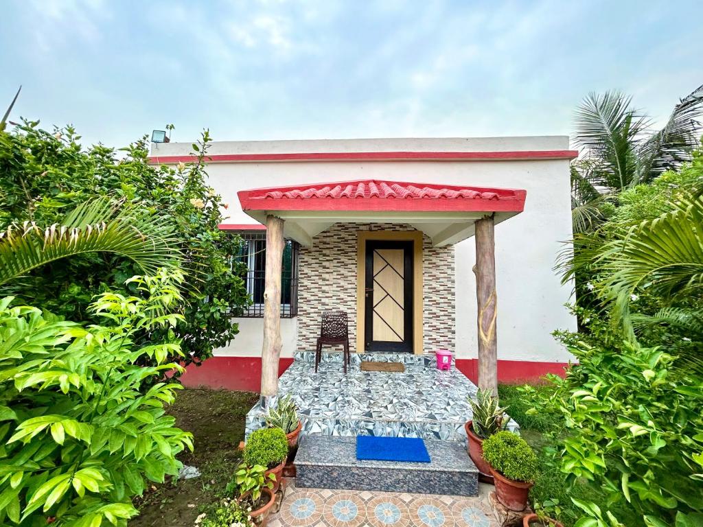 een klein wit huis met een rood dak bij Pet Friendly Cottage Room in Kolkata in Calcutta