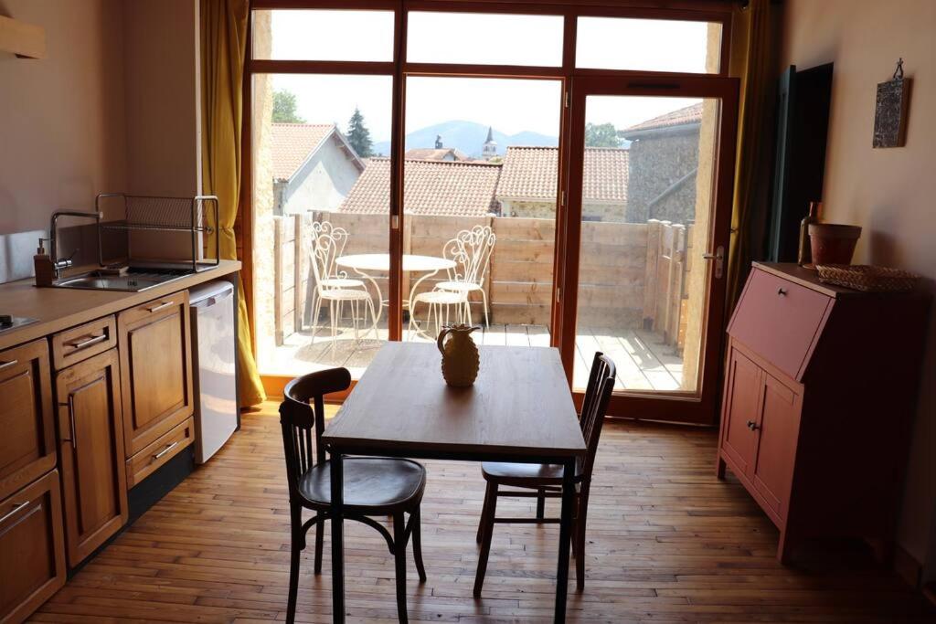 a kitchen with a table and chairs and a window at Nestudio : studio pour 2 / 3 personnes in Saint-Laurent-de-Neste