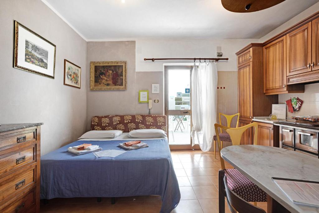 um pequeno quarto com uma cama e uma cozinha em Appartamento Arianna em Polverara