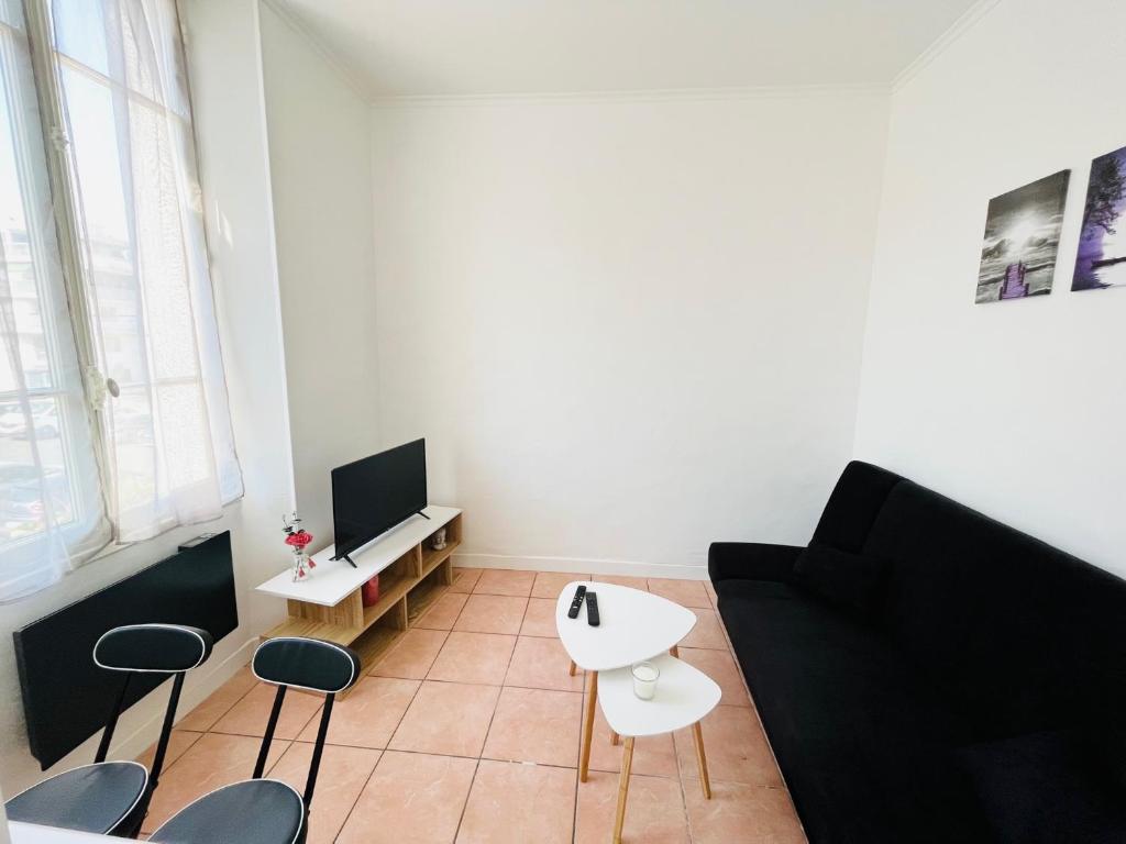 un salon avec un canapé, une table et des chaises dans l'établissement Studio centre Golfe Juan, à Vallauris