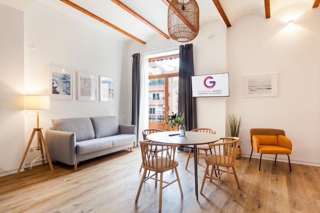 ein Wohnzimmer mit einem Tisch, Stühlen und einem Sofa in der Unterkunft Puerto Beach suites in Valencia