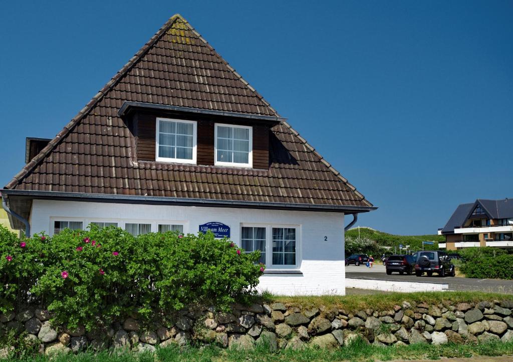 a white house with a brown roof at Villa am Meer in Westerland (Sylt)