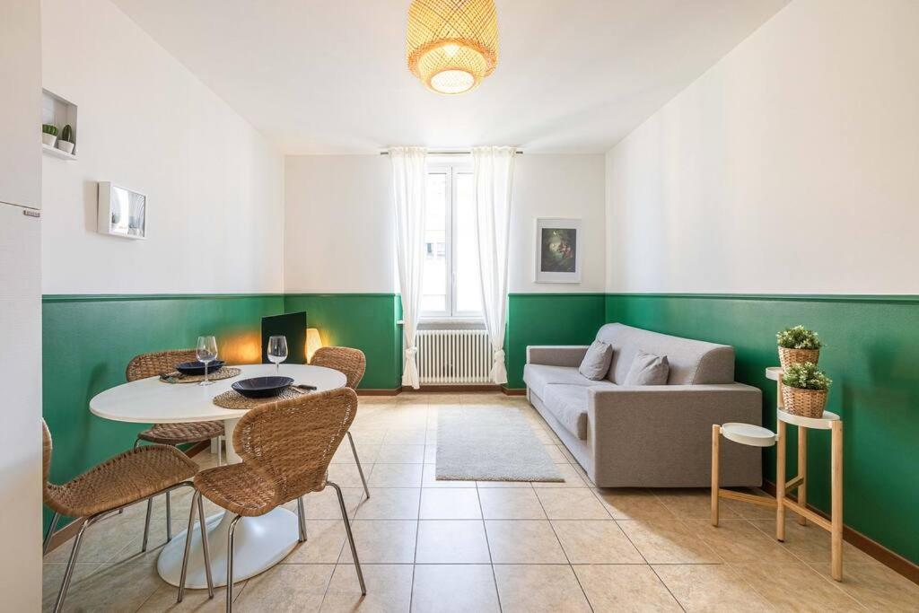 ein Wohnzimmer mit einem Sofa, einem Tisch und Stühlen in der Unterkunft Teatro Ariston, Elegante Appartamento Centrale in Sanremo