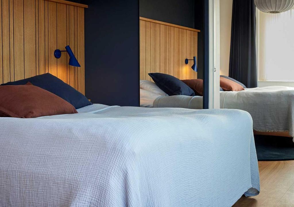 a bedroom with two beds and a mirror at Charlottehaven in Copenhagen