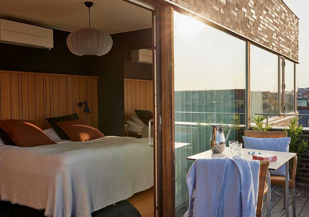 a bedroom with a bed and a table and a window at Charlottehaven in Copenhagen