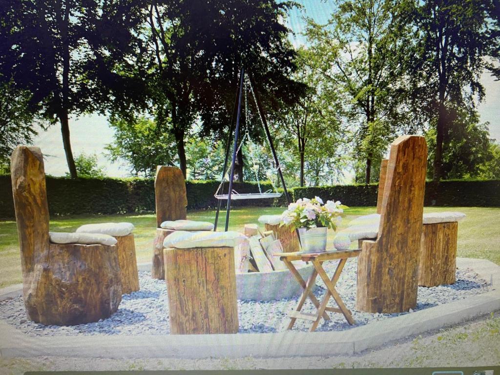 Ferienhaus Dröfter Blick في مونشاو: مجموعة من الكراسي الخشبية وطاولة مع الزهور
