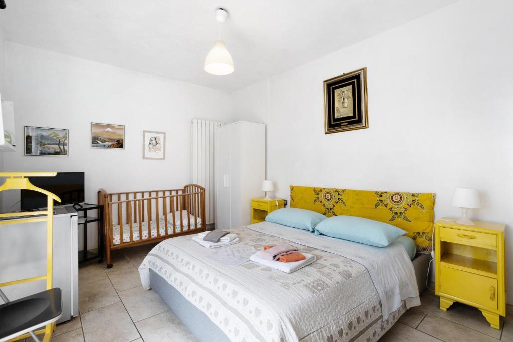 - une chambre avec un lit, un lit bébé et une télévision dans l'établissement Monolocale Arianna 1, à Polverara