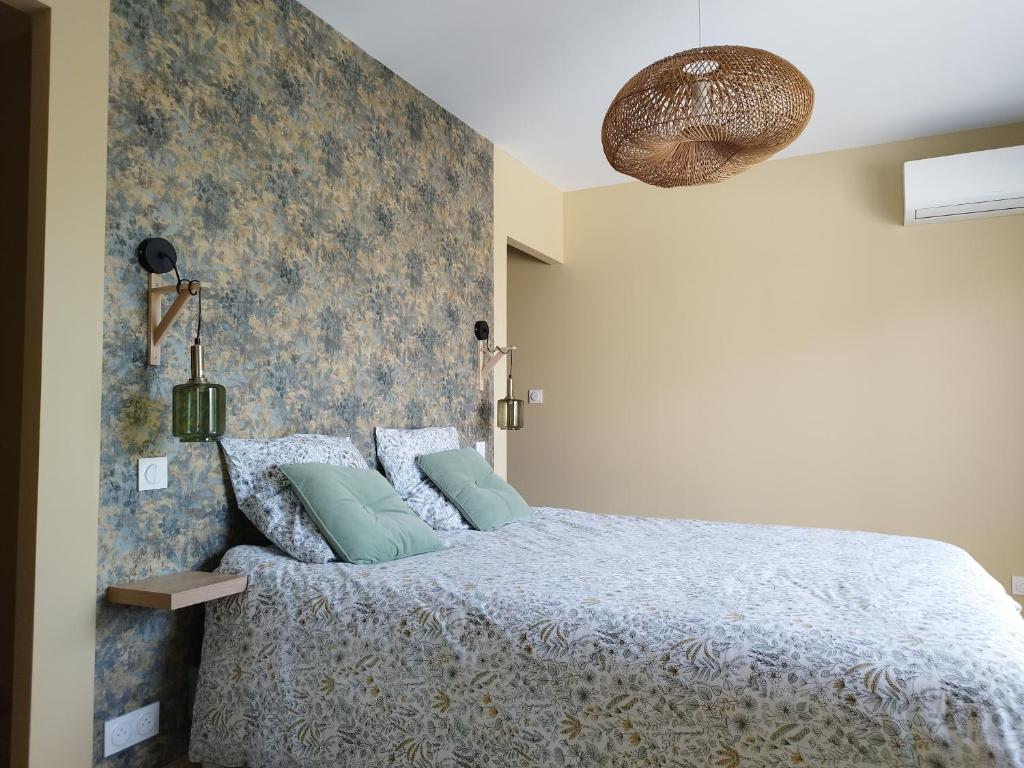 um quarto com uma cama com uma parede azul em Domaine de l'Arbre Doré em Lèzan