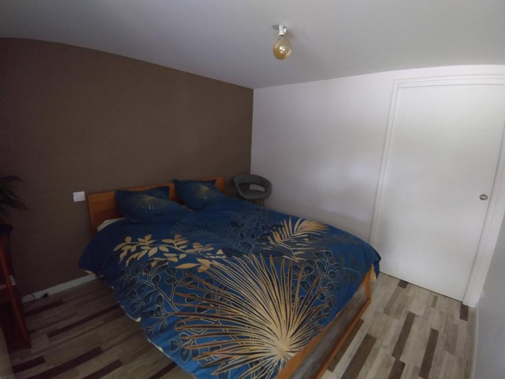 1 dormitorio con 1 cama con edredón azul en Chambre dans maison de campagne, en Bourg-des-Comptes