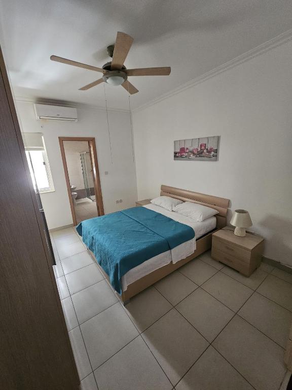 um quarto com uma cama e uma ventoinha de tecto em Beautiful two bedroom in center Bugibba em St. Paul's Bay