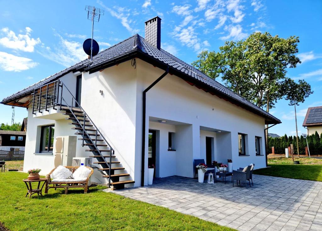 a white house with a spiral staircase in a yard at Apartament Amelia1 in Świnoujście