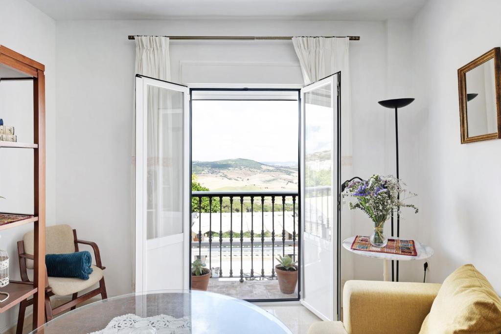 a living room with a glass door leading to a balcony at Casa Soumia in Vejer de la Frontera