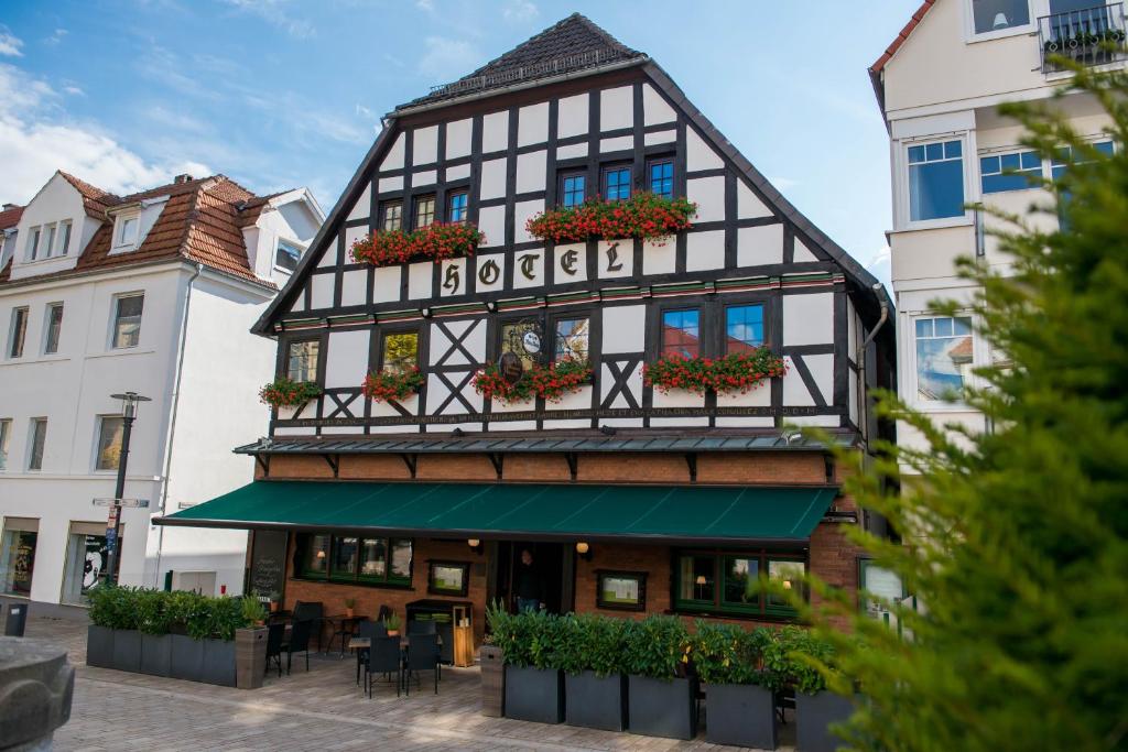 a black and white building with potted plants at Hotel zum Braunen Hirschen in Bad Driburg