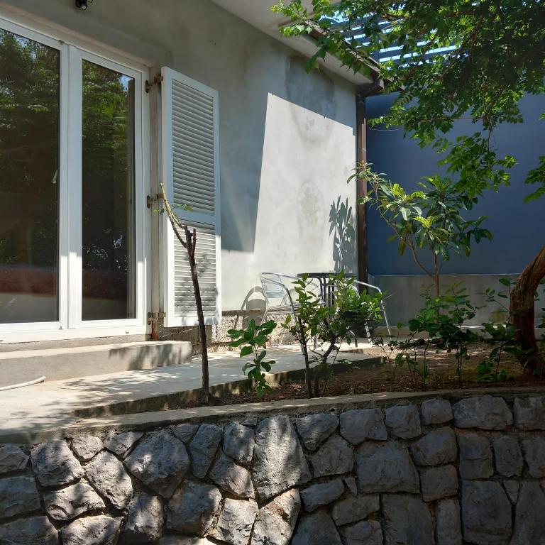 a house with a window and a stone wall at Apartman Selce in Selce