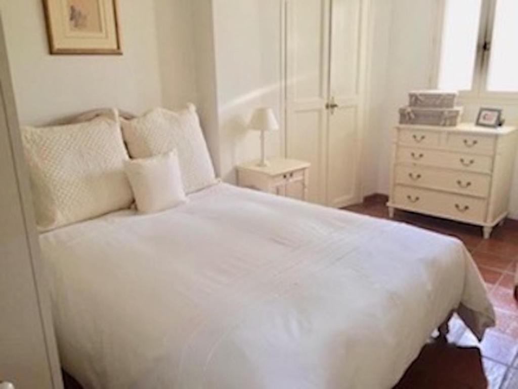 une chambre avec un lit blanc et une commode dans l'établissement Cœur de Cassis - 200 m du port et plage - Parking privé, à Cassis