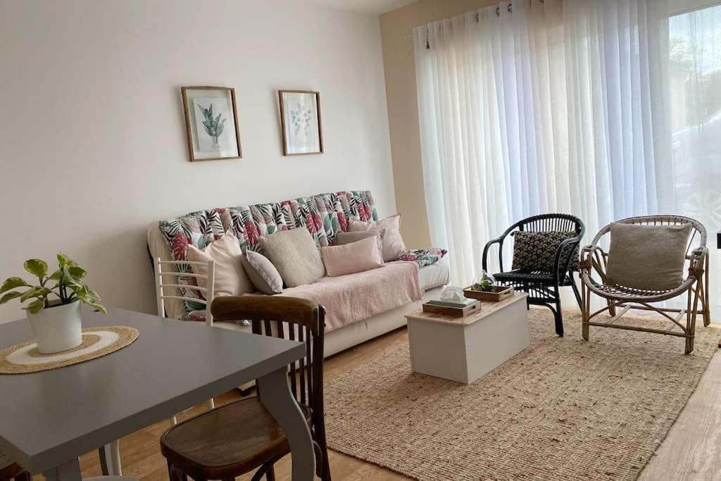 a living room with a couch and chairs and a table at L’atelier du Bois de Charbuy in Charbuy